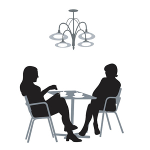 Black and white image of two women having coffee at a round table. A chandelier hangs over the table.